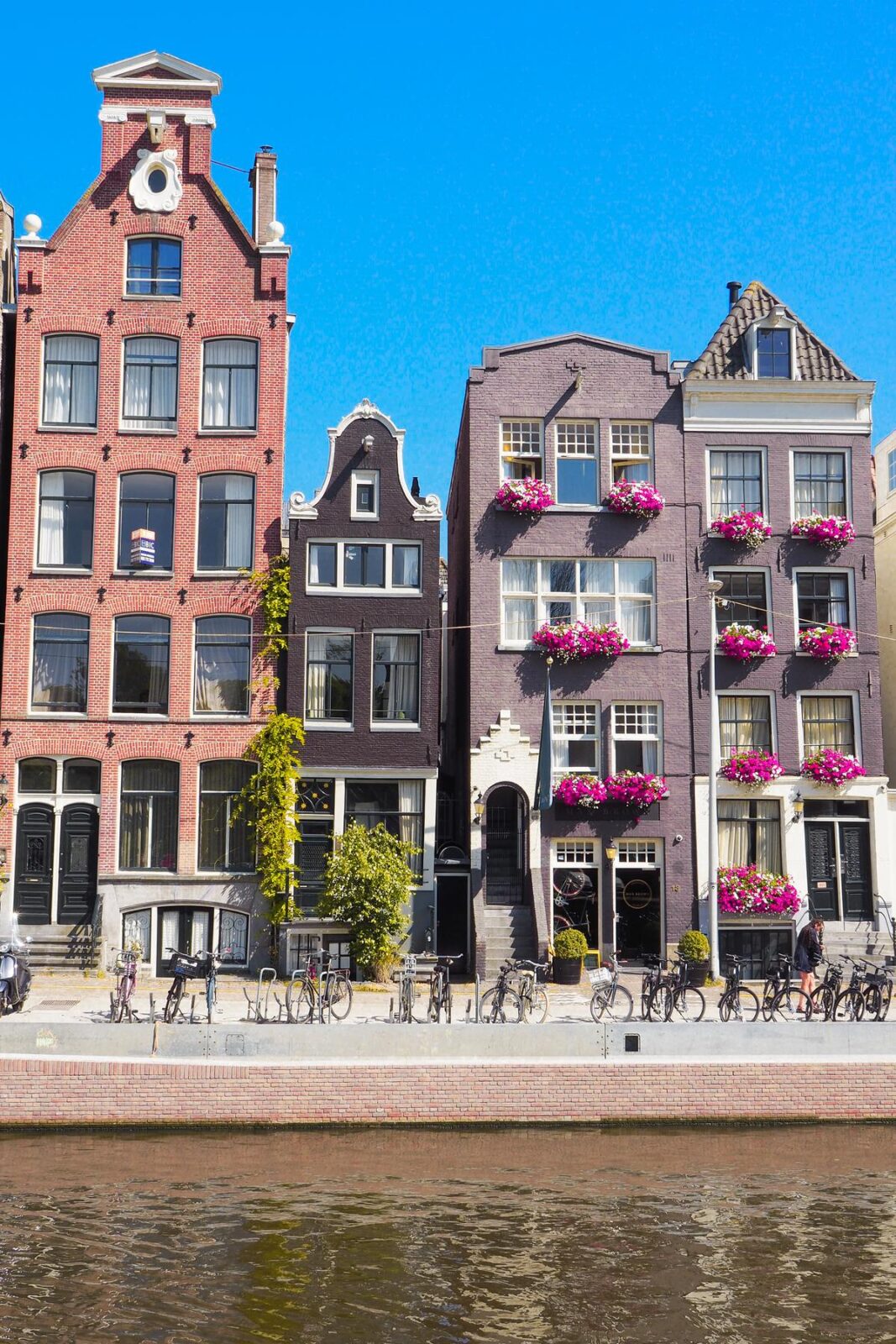 Amsterdam canal houses with gabled facades and flower boxes