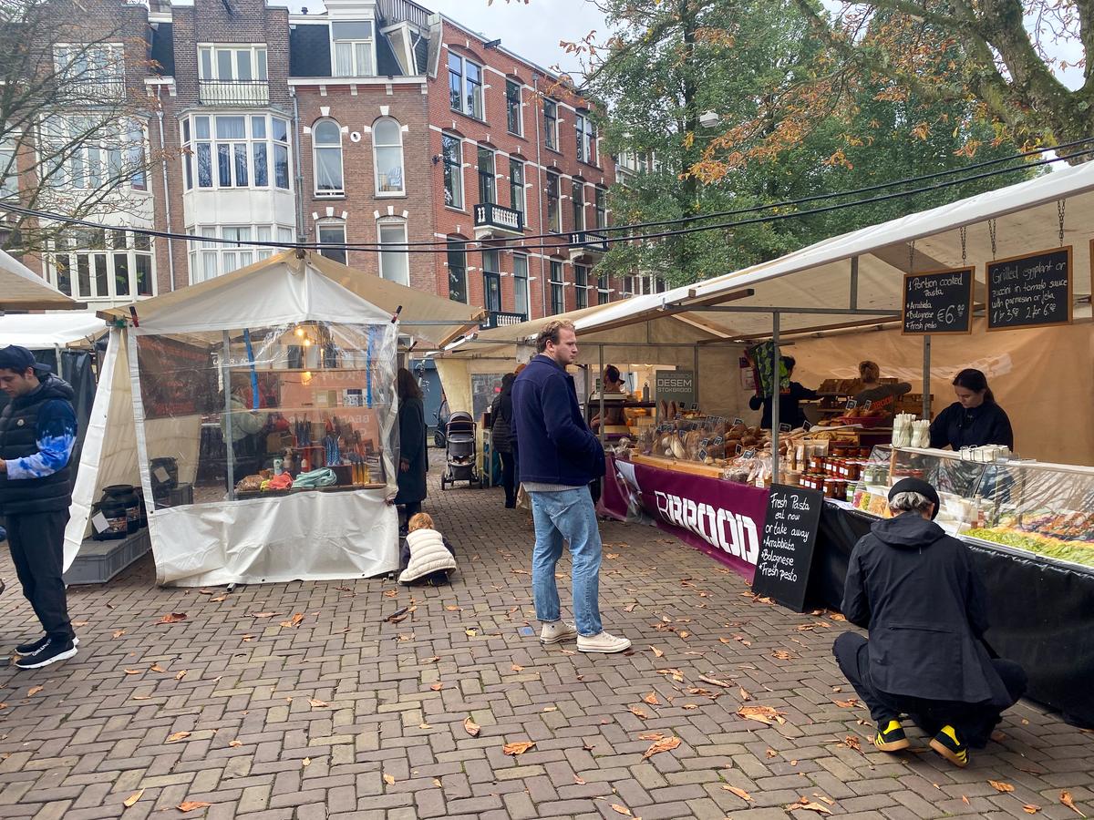 Zuidermarkt bustling with shoppers among Amsterdam's Dutch architecture and market stalls