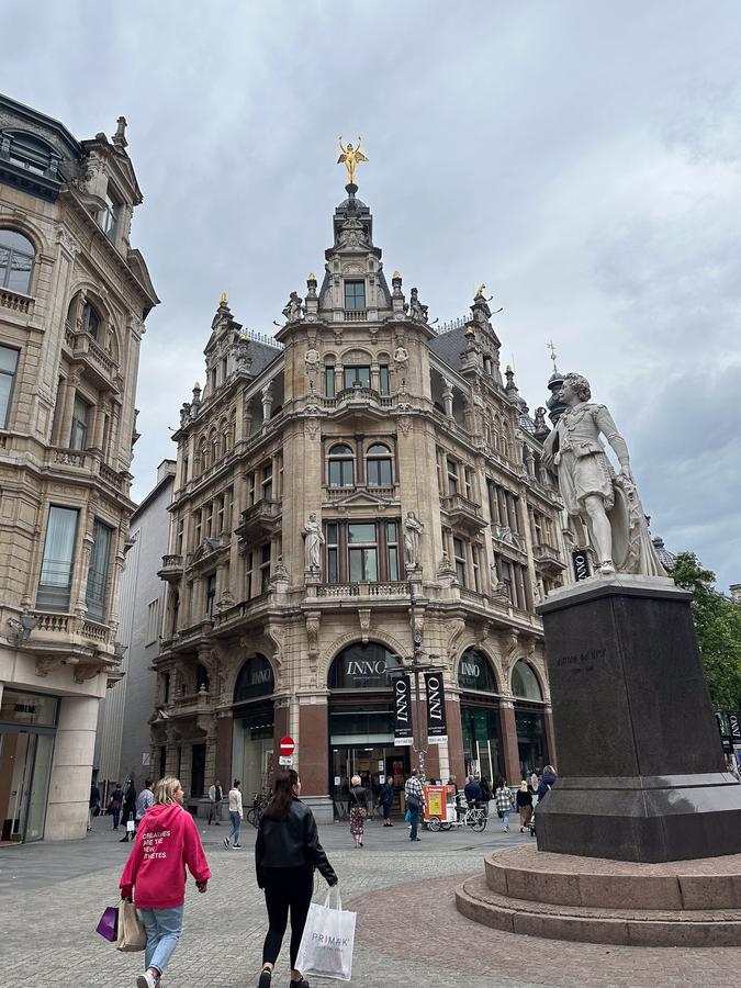 Pedestrians walking past shops and historic facades on Meir in Antwerp