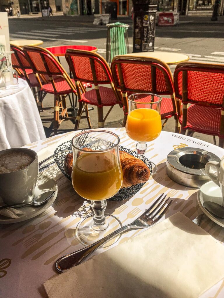 Authentic French breakfast at Le Royal Opera, Paris - Traditional Parisian morning scene with croissant, coffee, and orange juice.