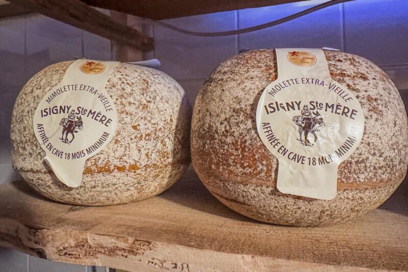 Two aged Mimolette Extra-Vieille cheese wheels with 18-month cave aging process.