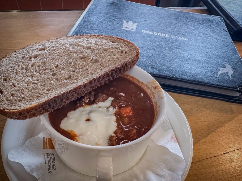 Traditional Goulash Soup with sour cream and bread