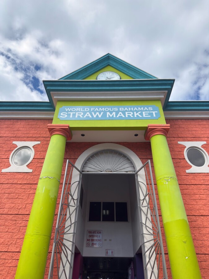 Colorful entrance to the World Famous Bahamas Straw Market in downtown Nassau, with lime-green columns and a clock gable