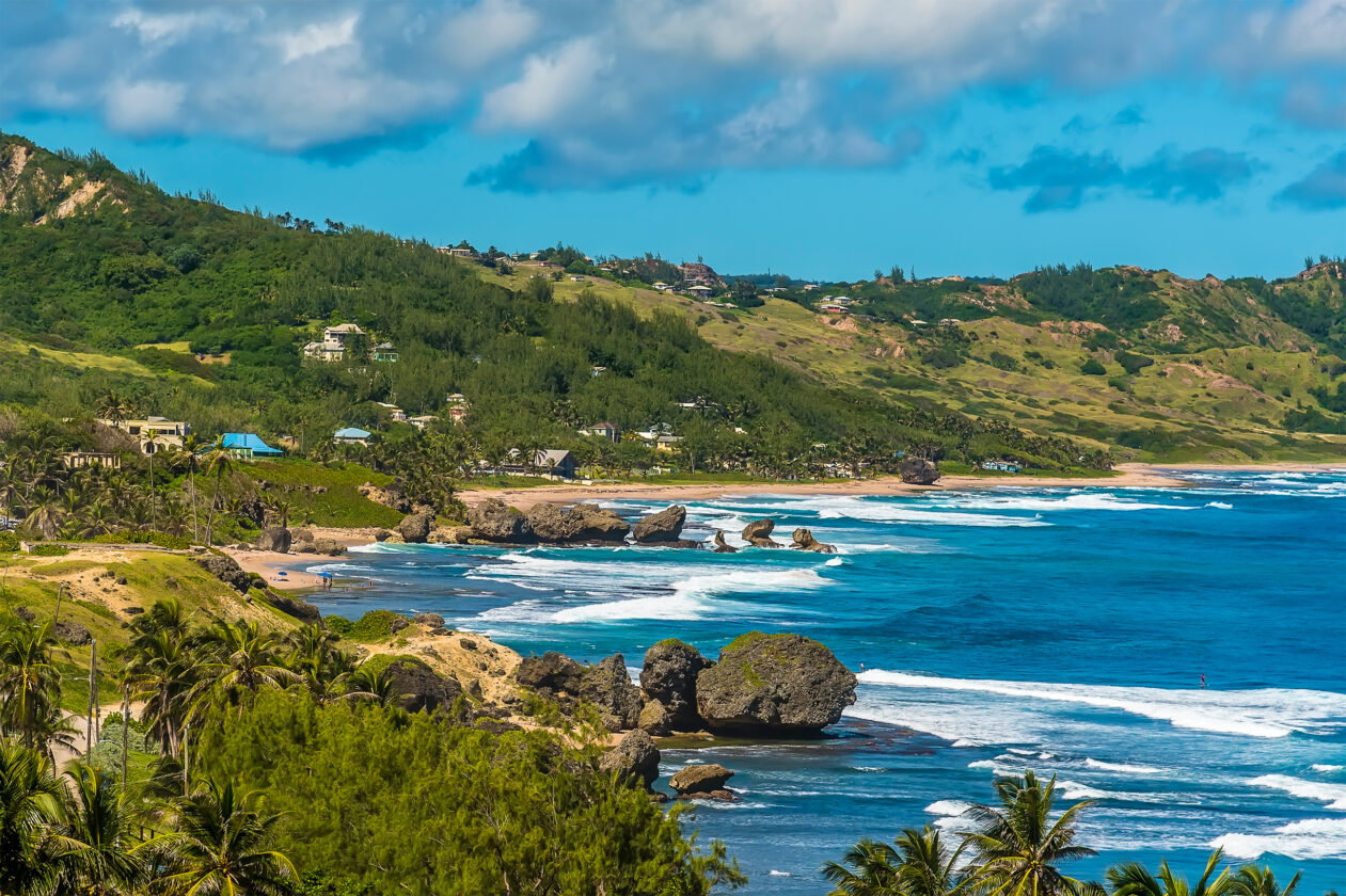 Bathsheba Beach, Barbados: turquoise Atlantic surf on a rocky coastline with green hills.