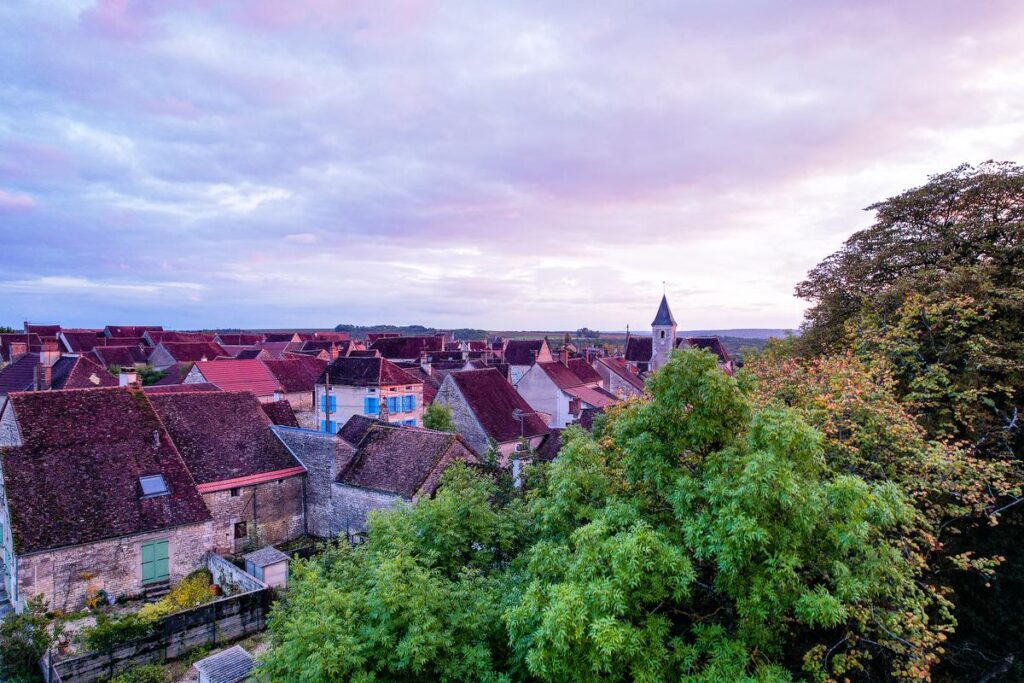 Sunset over Beru Village, France with church spire and colorful sky
