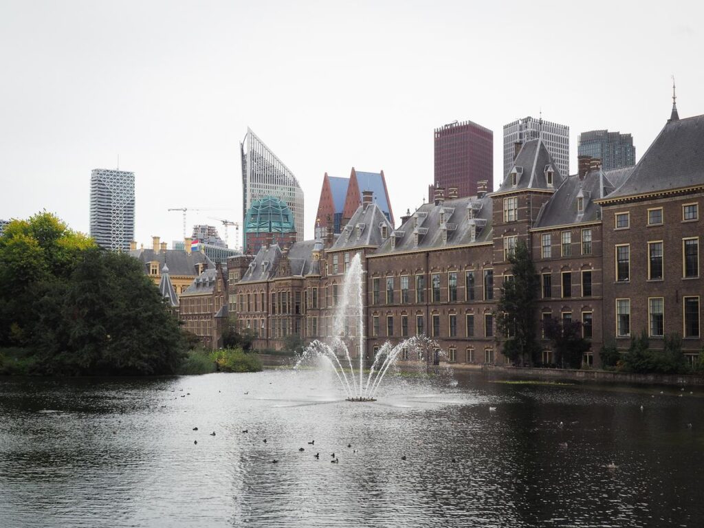 Binnenhof Parliament with The Hague skyline and pond reflection in Netherlands