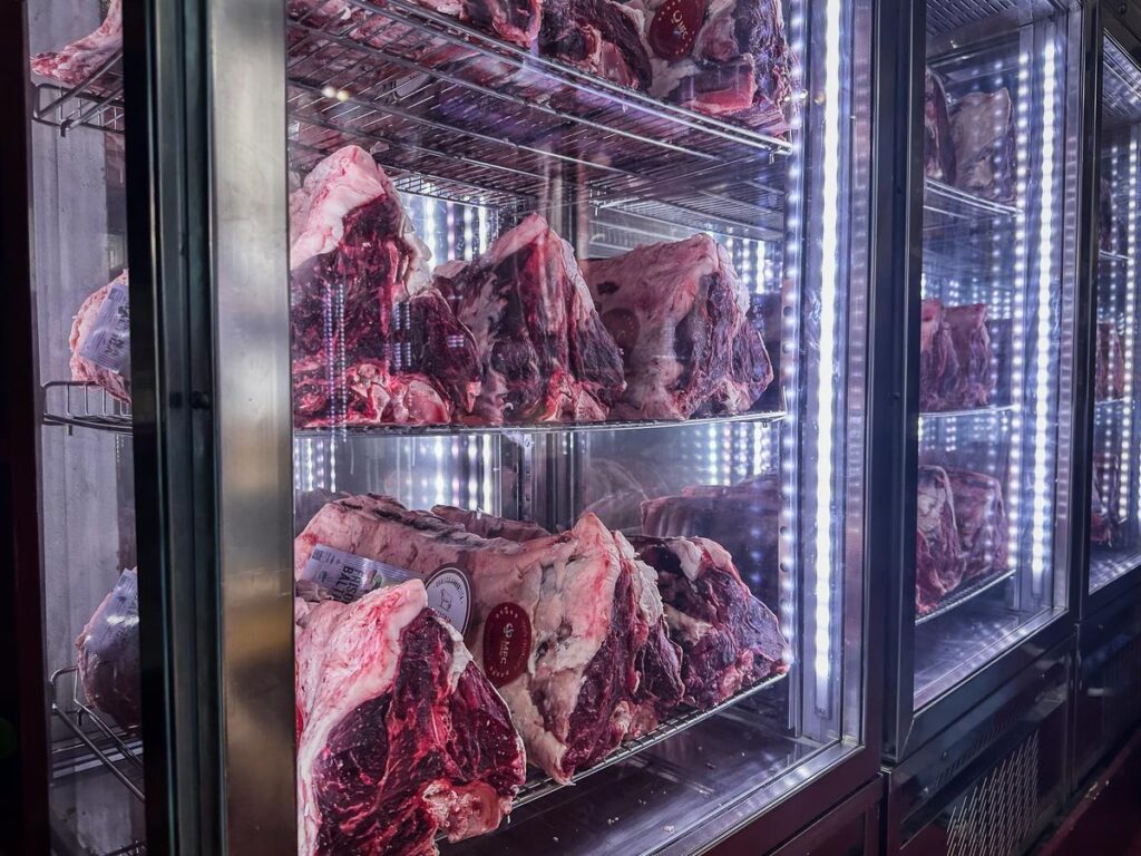 Authentic Bistecca alla Fiorentina steaks on display at a Florence trattoria
