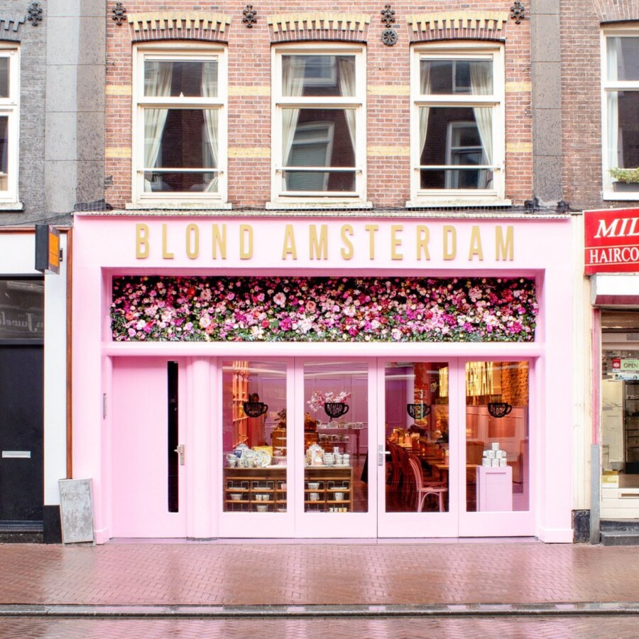 Blond Amsterdam pink storefront among shops in Amsterdam.