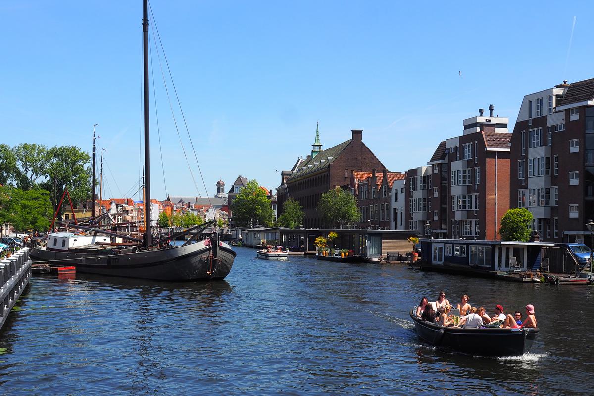Boats on the canals in Leiden, showcasing traditional Dutch architecture and city life.