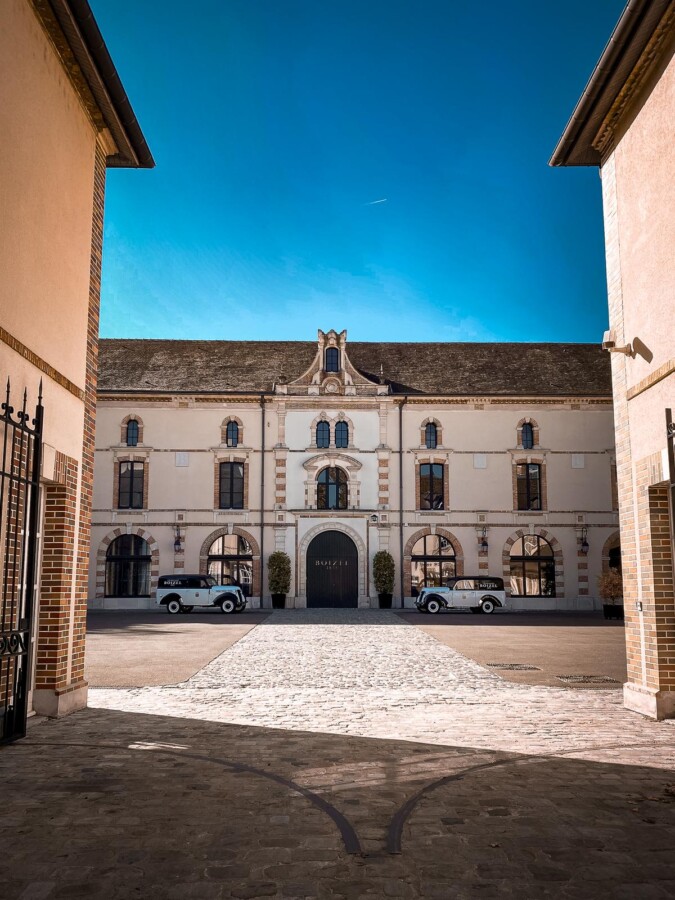 Boizel Champagne House in Epernay, France, vintage cars parked in front courtyard under clear blue sky