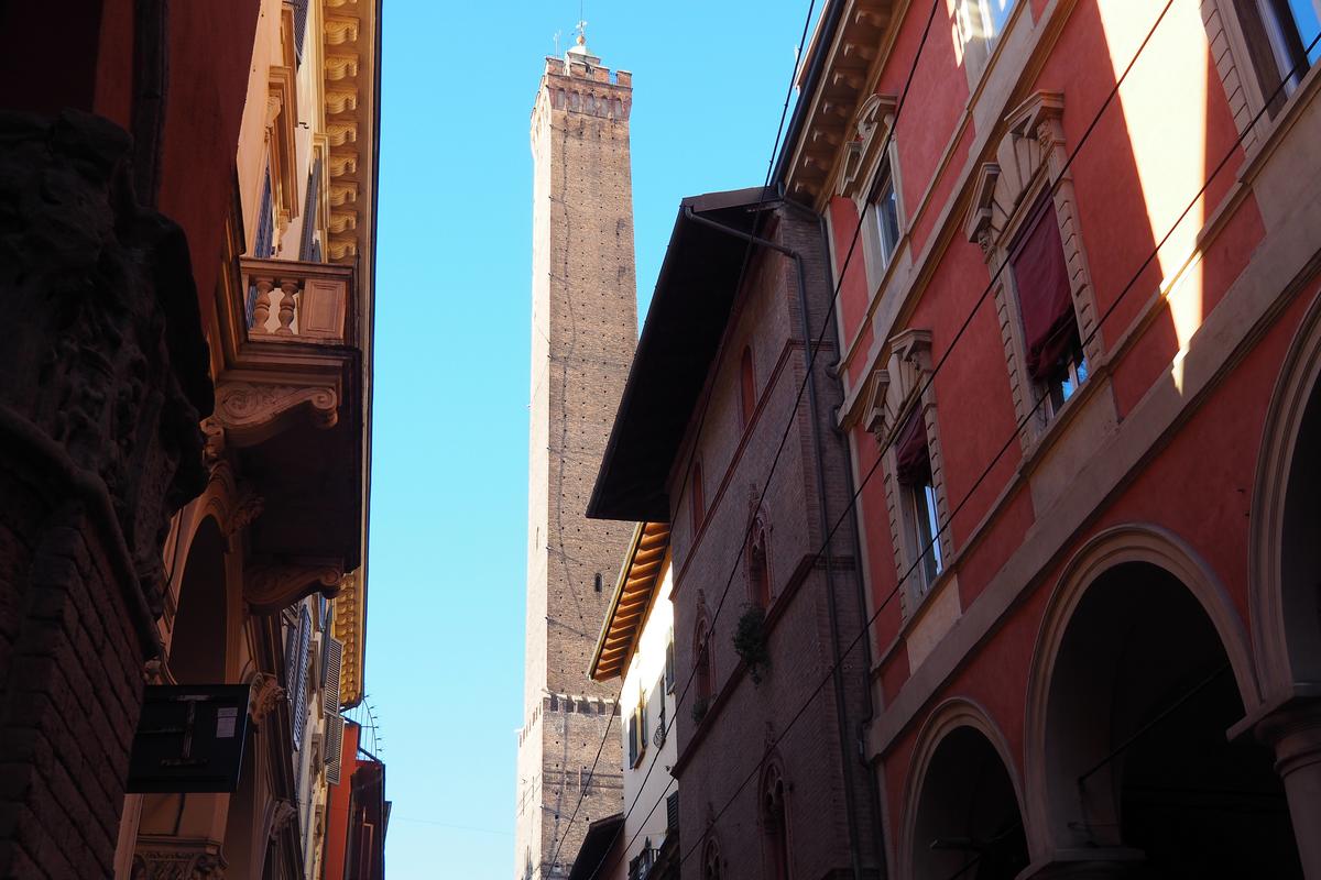 Bologna medieval tower and terracotta rooftops under a blue sky