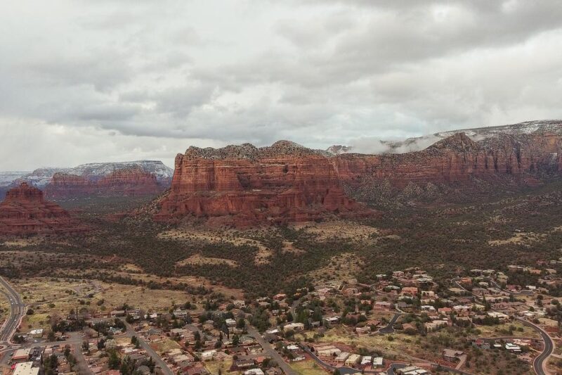 Aerial panorama of Sedona's iconic red rock formations and townscape landscape.