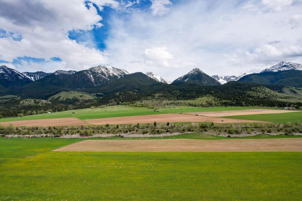 Aerial view of snow-capped mountains and lush valley in Paradise Valley, Montana