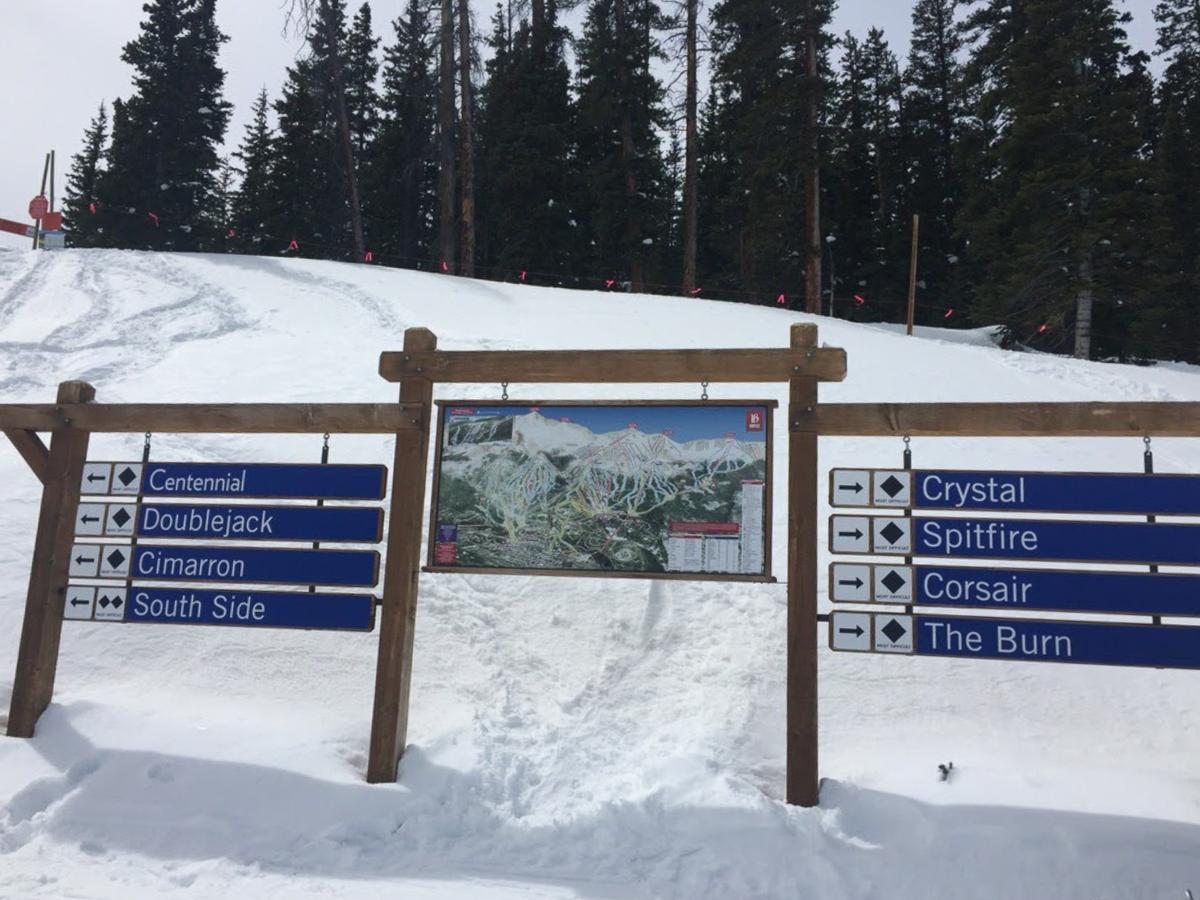 Breckenridge Ski Resort trail signs and map amidst snowy pines