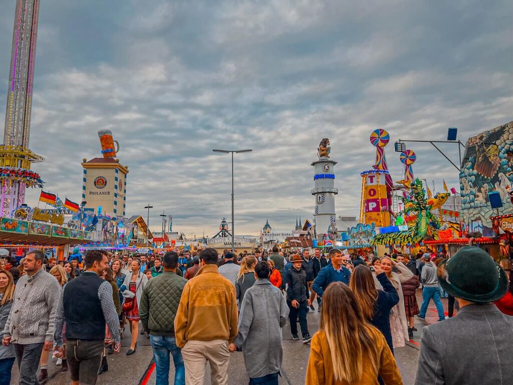 Bustling Oktoberfest scene with amusement rides and festive crowds in Munich.