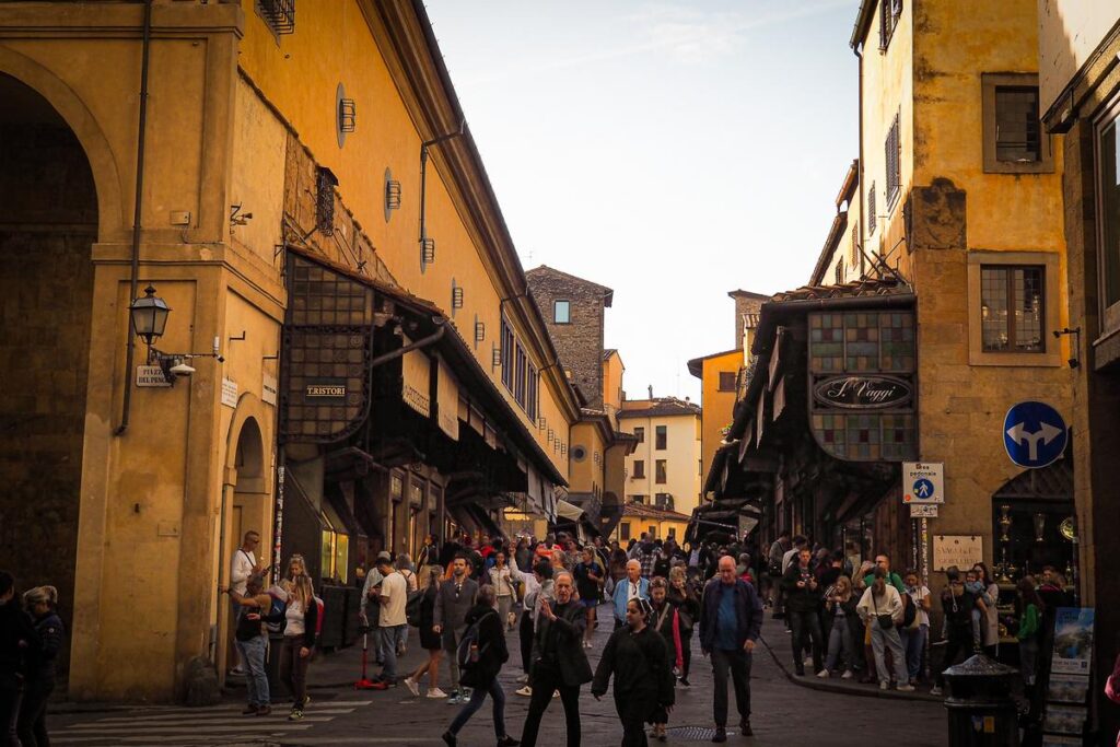 Bustling scene on the historic Ponte Vecchio, Florence, Italy, showcasing vibrant daily life and Italian charm.