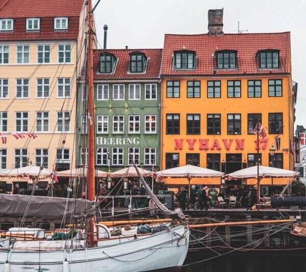 Captivating Nyhavn waterfront scene with colorful historic houses and classic wooden boats in Copenhagen, Denmark.