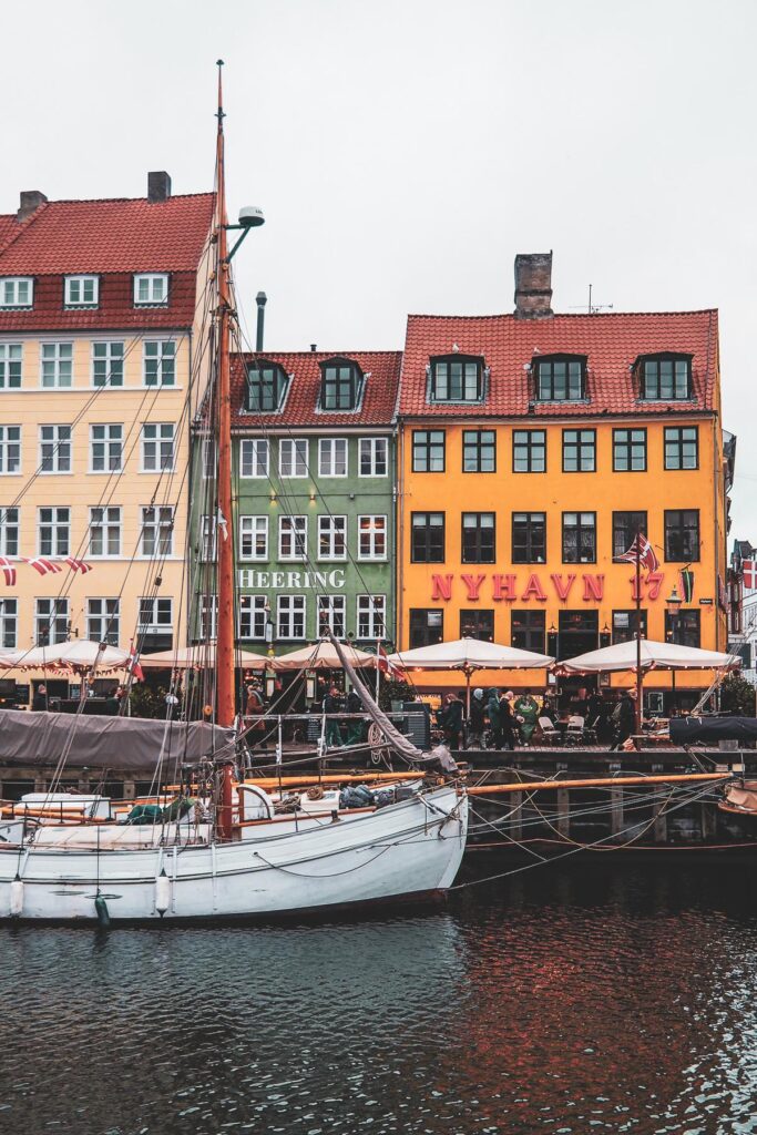 Captivating Nyhavn waterfront scene with colorful historic houses and classic wooden boats in Copenhagen, Denmark.