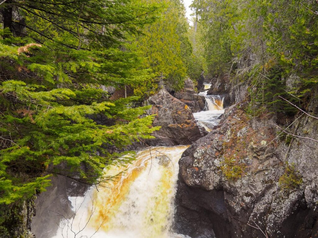 Cascade River Waterfalls in lush Lutsen, MN forest, a scenic hiking destination