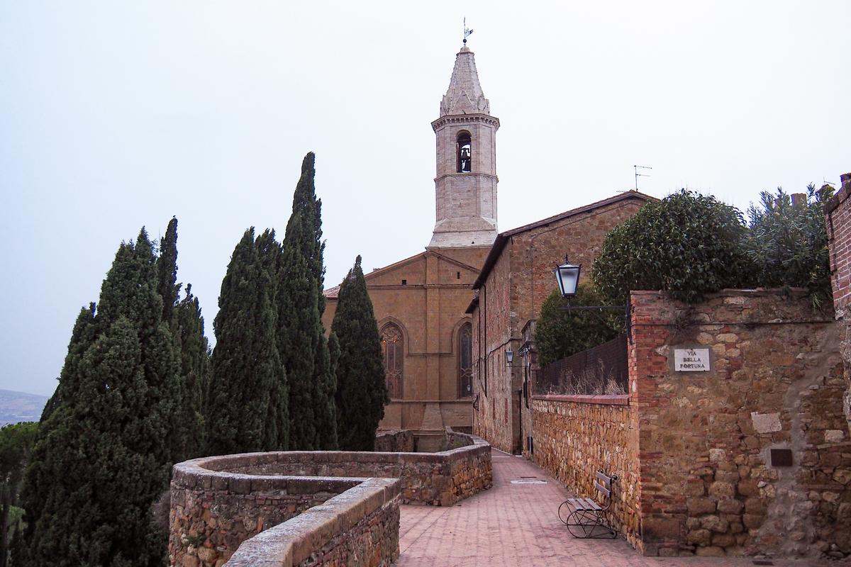 Charming view of Via Del Casello in Pienza, Tuscany with historic church tower, cypress trees, and tranquil streets.