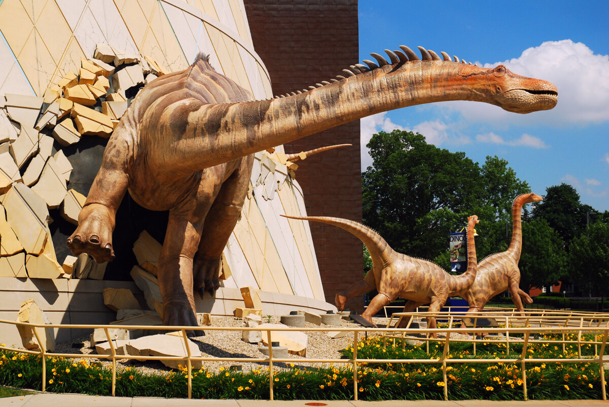A sculpture of huge dinosaurs breaking out the wall of Children's Museum of Indianapolis in Indianapolis, Indiana