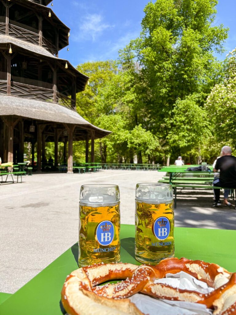 Vibrant snapshot of Chinese Tower Beer Garden in Munich, featuring HB beer, pretzel, and leisurely patrons on a sunny day