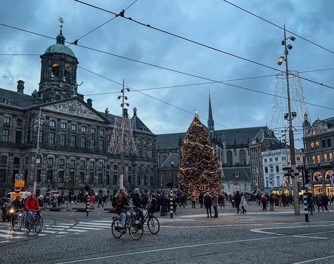 Christmas tree on Dam Square in Amsterdam, Netherlands, illuminated with vibrant holiday lights