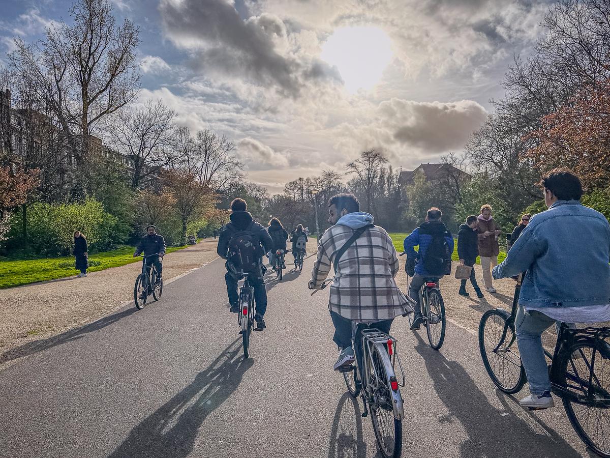 Cyclists and pedestrians sharing a path in Vondelpark on a sunny day