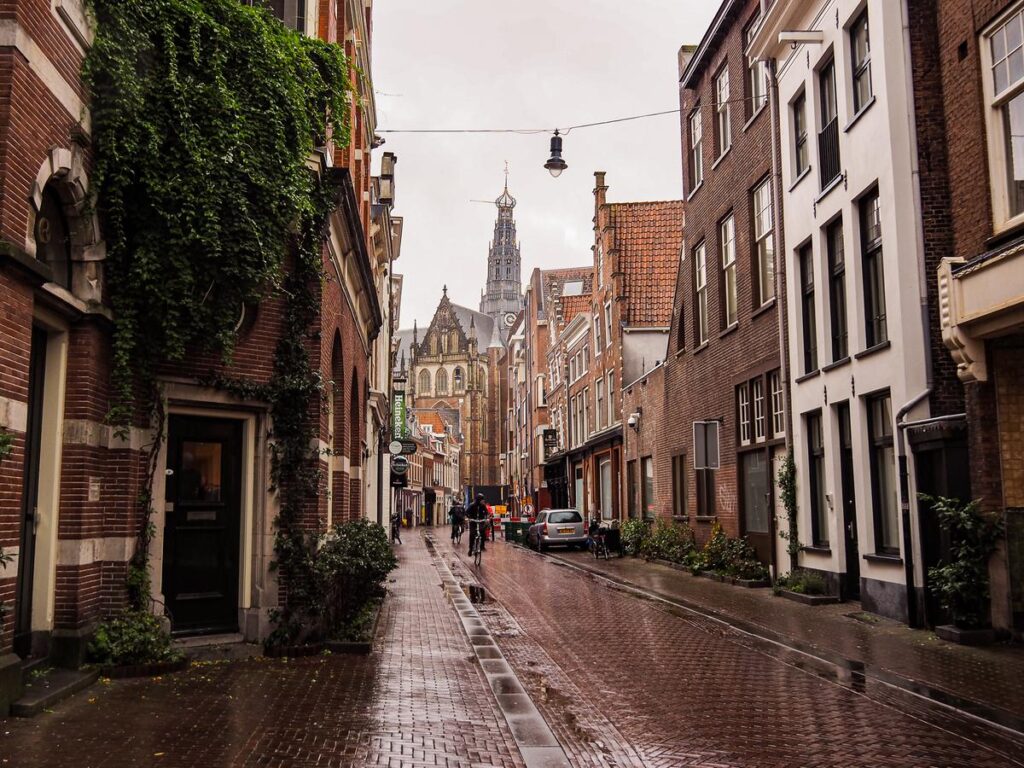 Cyclists riding on a rain-slicked cobblestone street in Haarlem