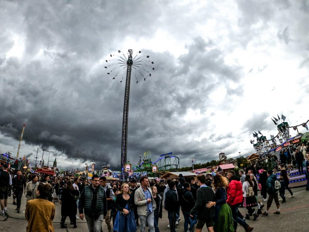 Dynamic Oktoberfest crowd enjoying festival under stormy skies