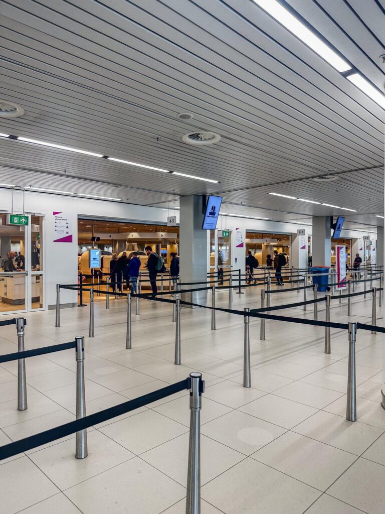 Efficient airport security checkpoint with streamlined queuing system and passengers waiting for screening.