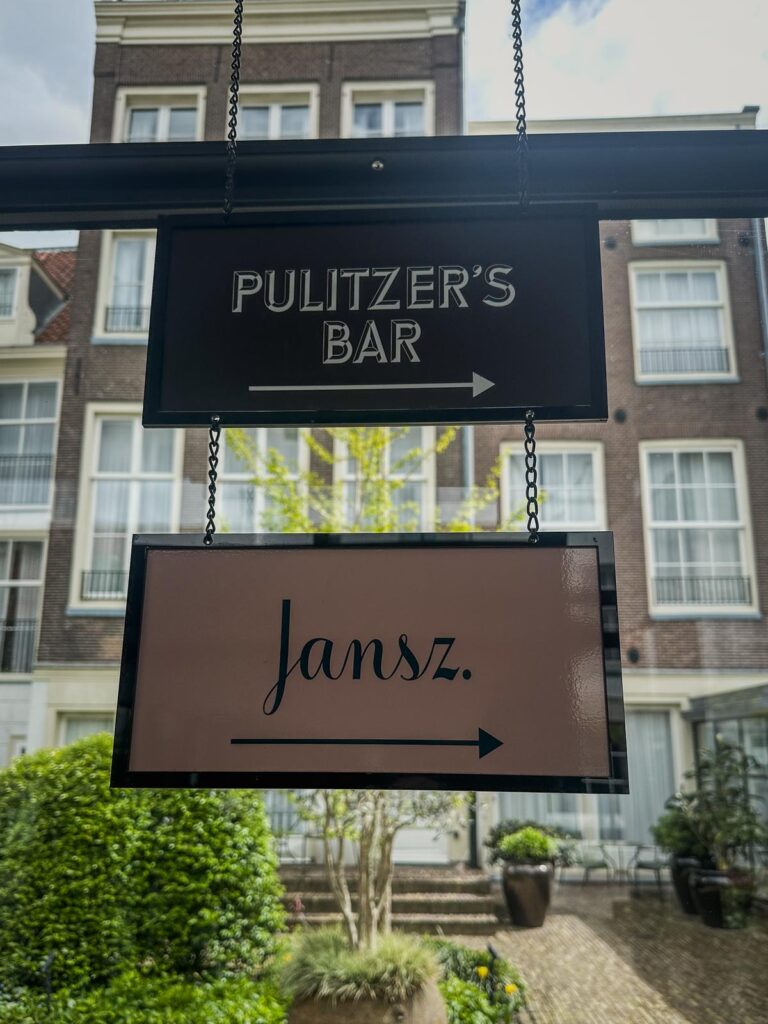 Elegant hanging signs at Pulitzer Hotel, Amsterdam pointing to Pulitzer's Bar and Jansz Restaurant