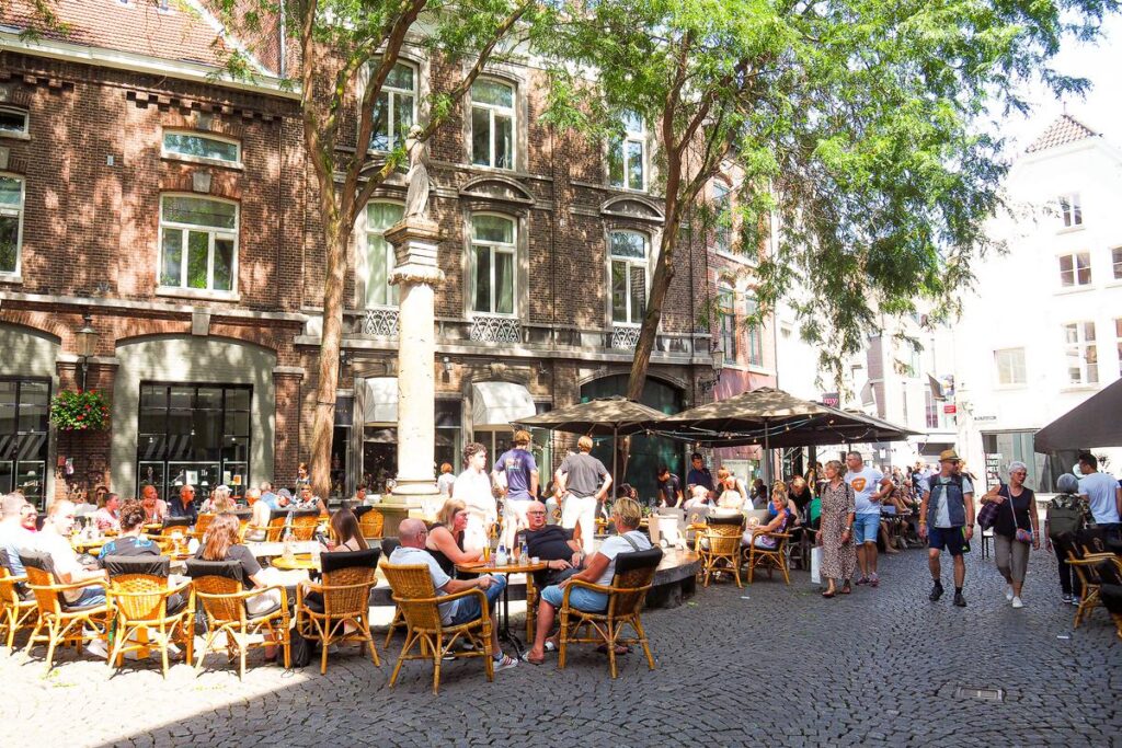 Enjoy alfresco dining in Maastricht's historic city center on a sunny day.