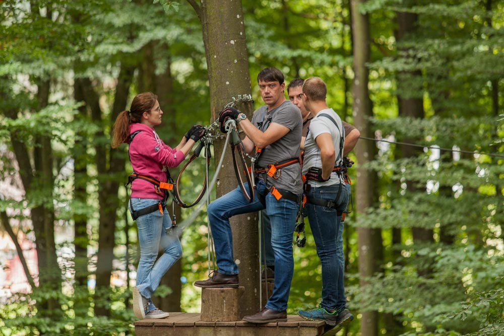 Group prepares for zip lines in Germany on a forest ropes course.