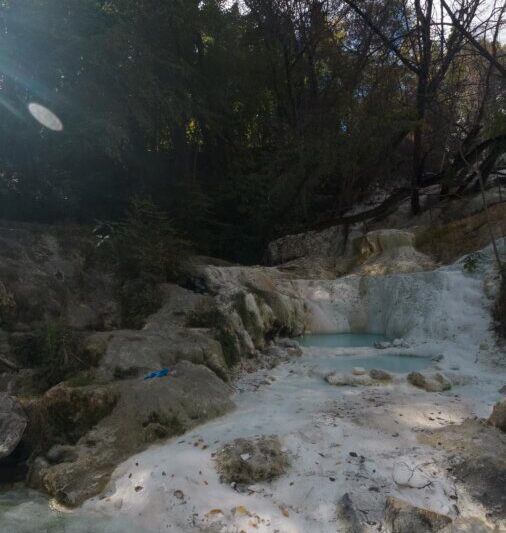 Tranquil Fosso Bianco hot springs surrounded by foliage in Tuscany