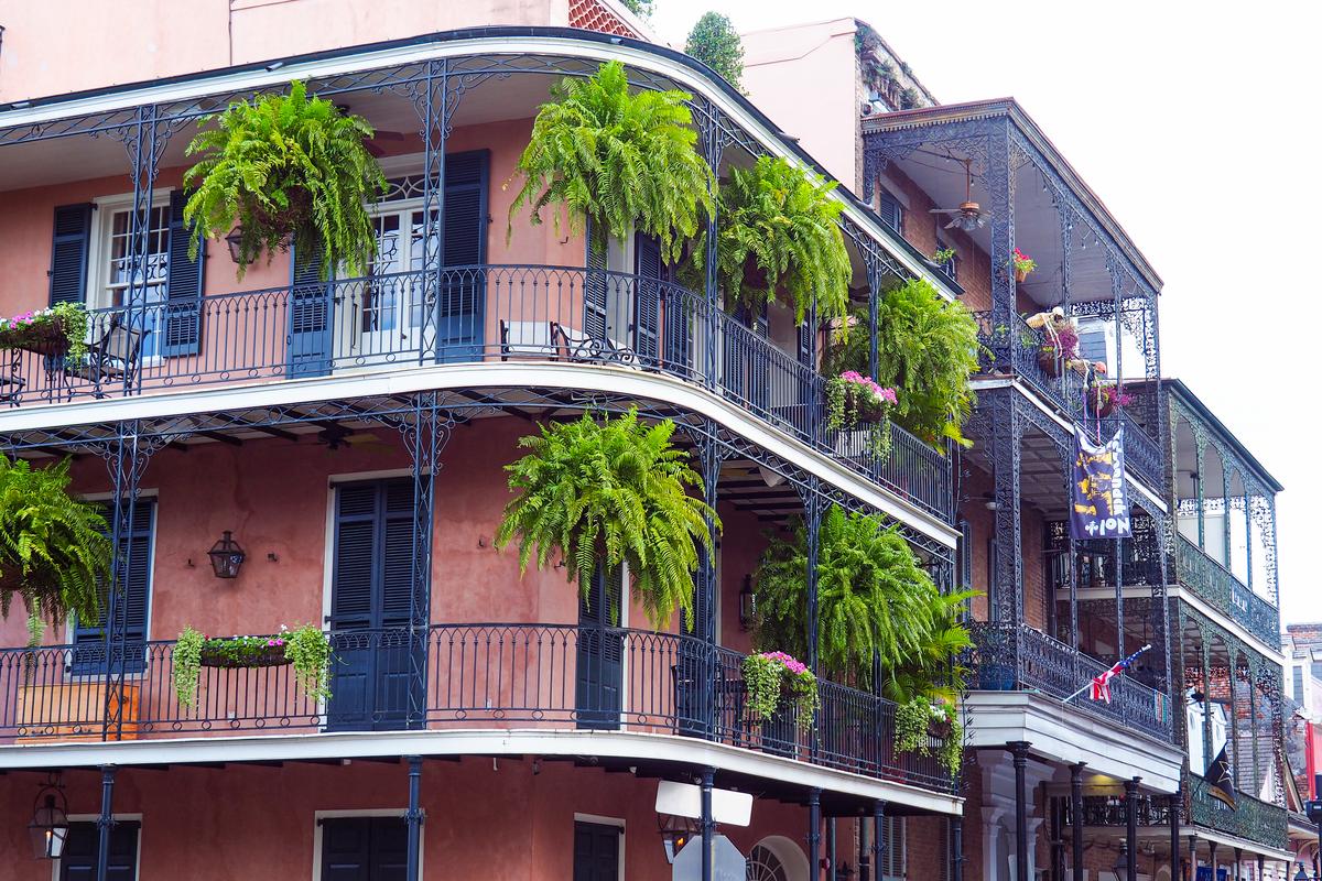 Historic French Quarter balconies in New Orleans with wrought iron and lush greenery architecture