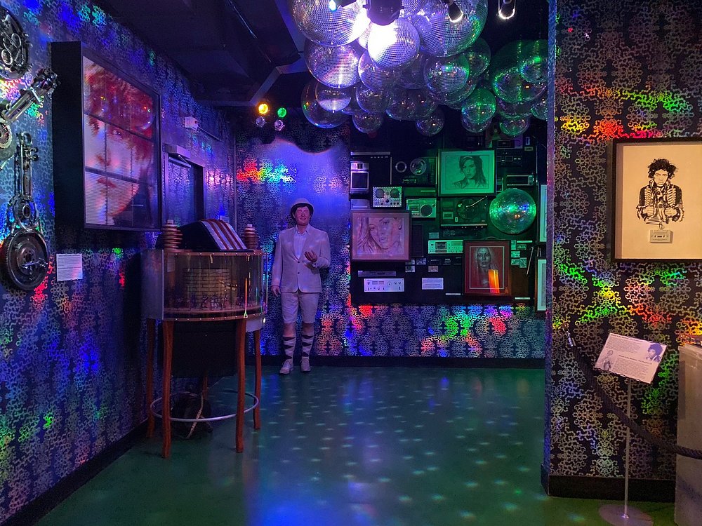 Interior gallery of retro technology and disco glamour, featuring mirrored balls and vintage audio equipment.