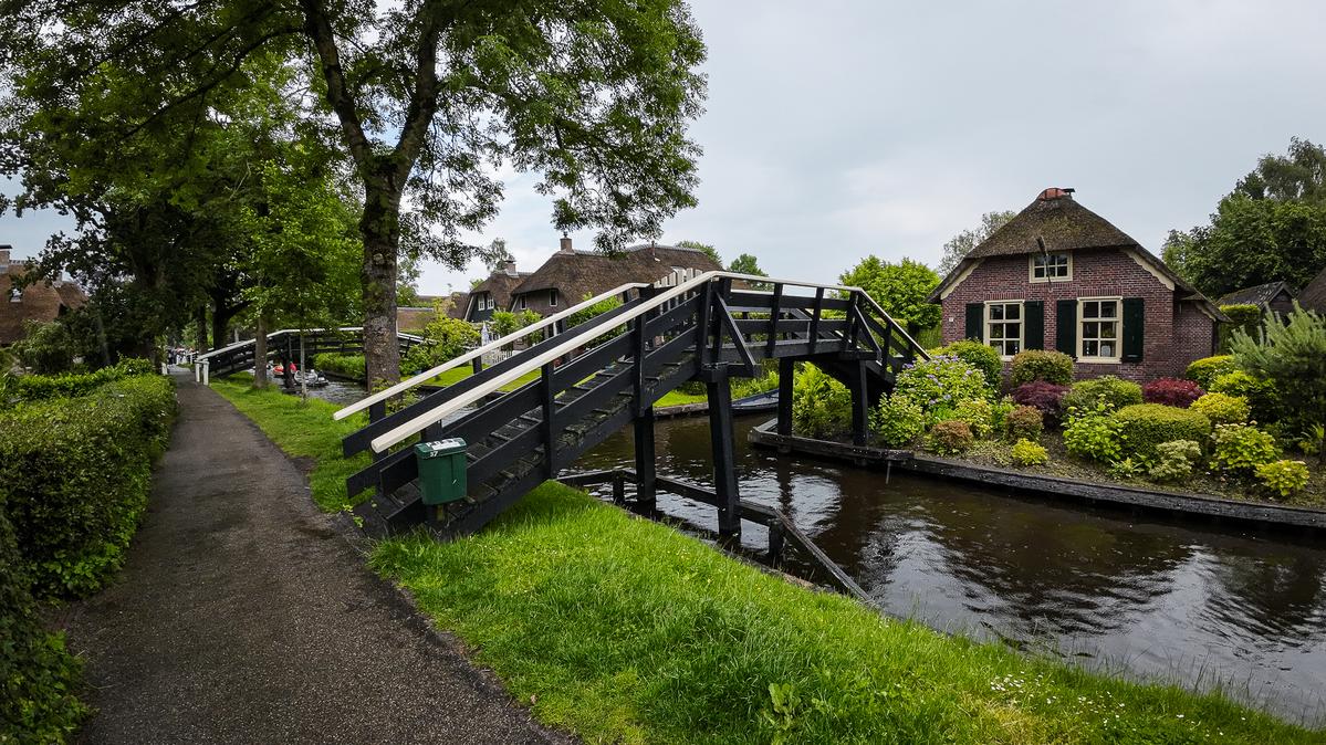 Idyllic Giethoorn canal with charming footbridge and traditional Dutch cottages