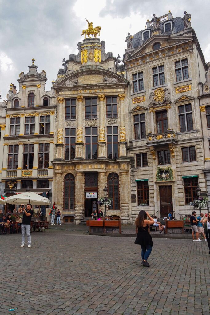 Baroque façade at Brussels Grand Place with tourist photographing