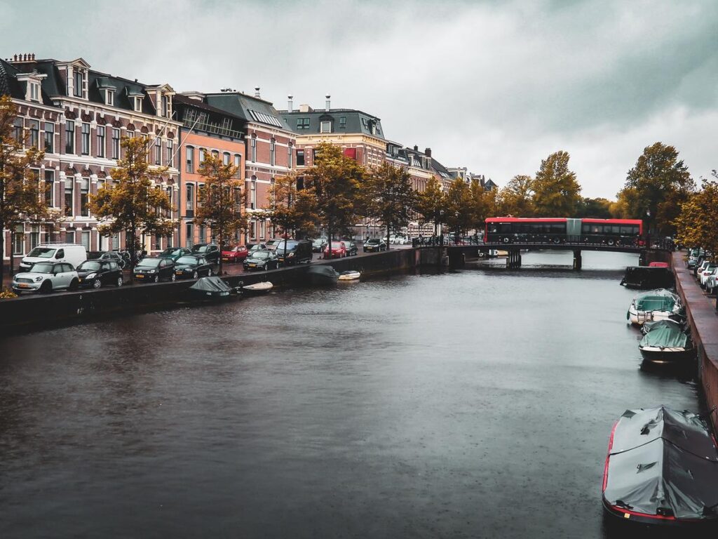Haarlem canal scene with historic architecture and tranquil waters, reflecting sky and red bridge