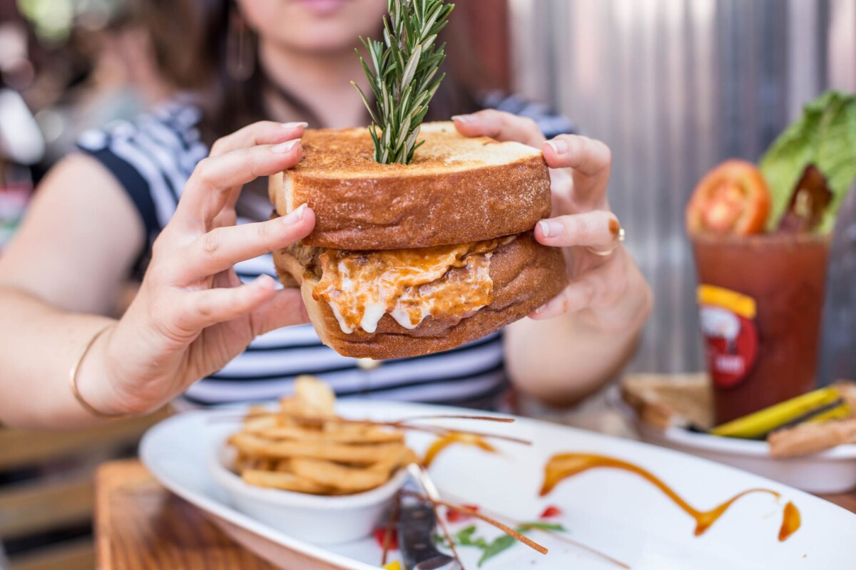 Hash House a Go-Go Is Worth the Stop! 2 Woman holding a huge sandwich served at Hash House A Go Go