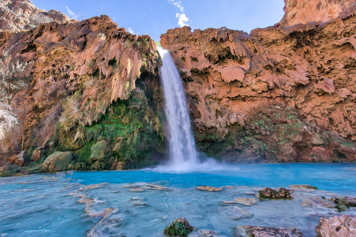 Havasu Falls turquoise pool and silky white waterfall in red Arizona canyon.