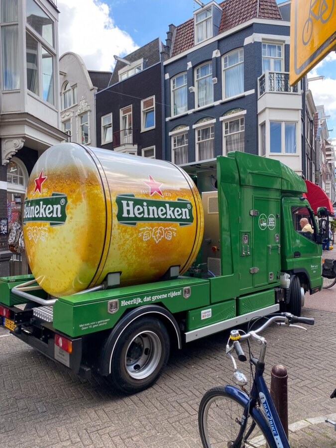 Heineken beer truck on Amsterdam cobblestone street with bikes and Dutch buildings