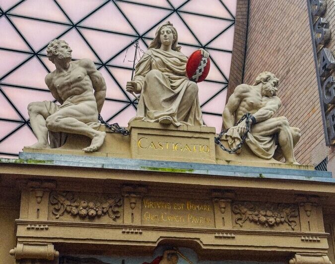 Amsterdam historic Rasphuispoort sculptures against modern glass roof
