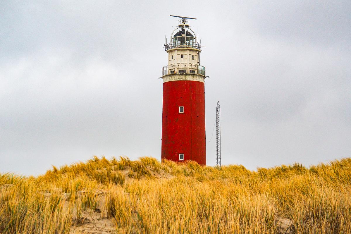 Historic red Texel Lighthouse in dunes, iconic maritime landmark on Texel Island, Netherlands