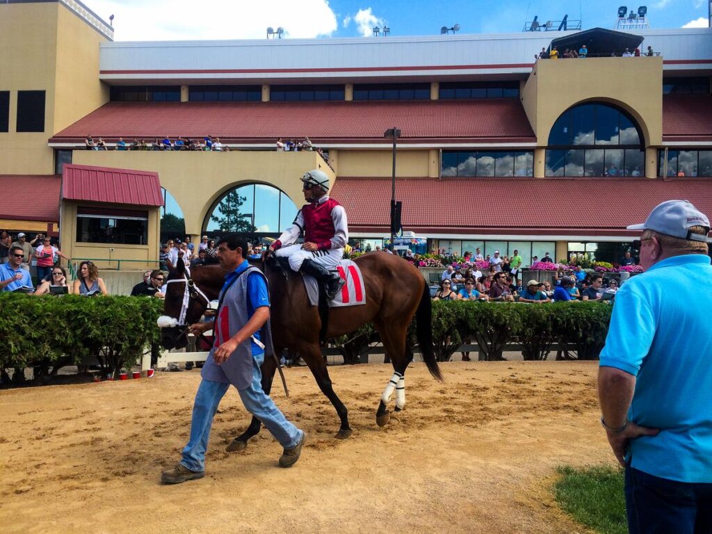 Jockeys racing past spectators at Canterbury Park in Shakopee