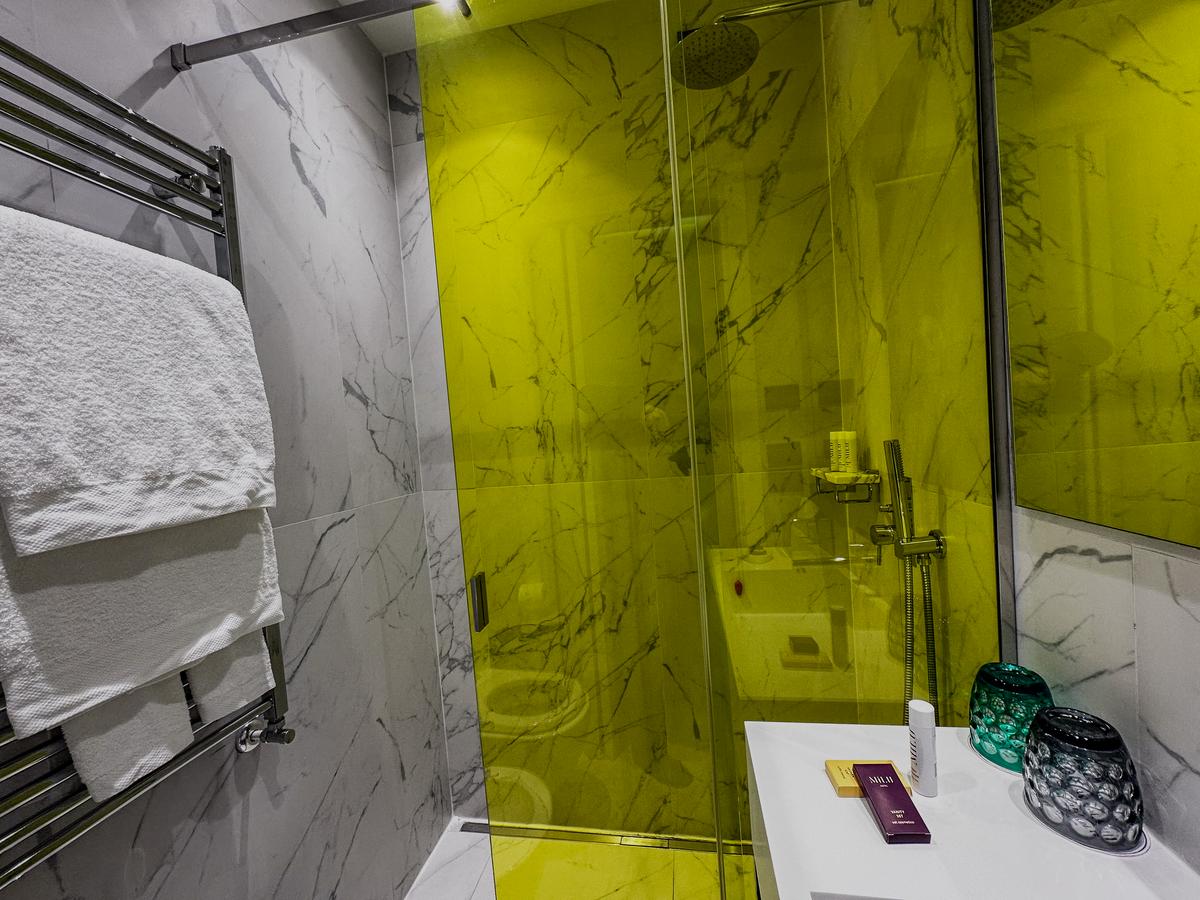 Luxurious Hotel Milu Florence bathroom with modern marble design and yellow shower