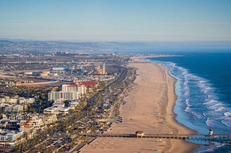 The wide sand and rolling waves of Huntington State Beach south of the Huntington Beach Pier
