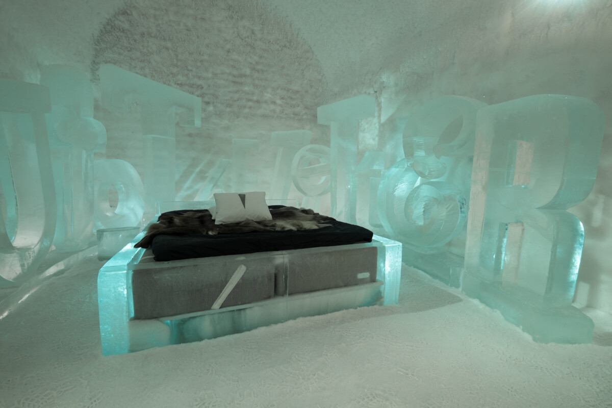 Carved ice walls and a bed inside an ICEHOTEL art suite