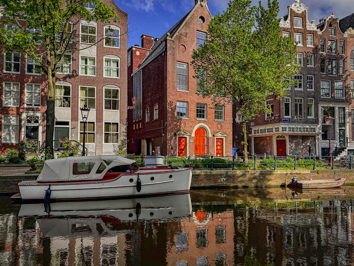 Amsterdam canal scene with historic Dutch architecture, boats, and serene waterways
